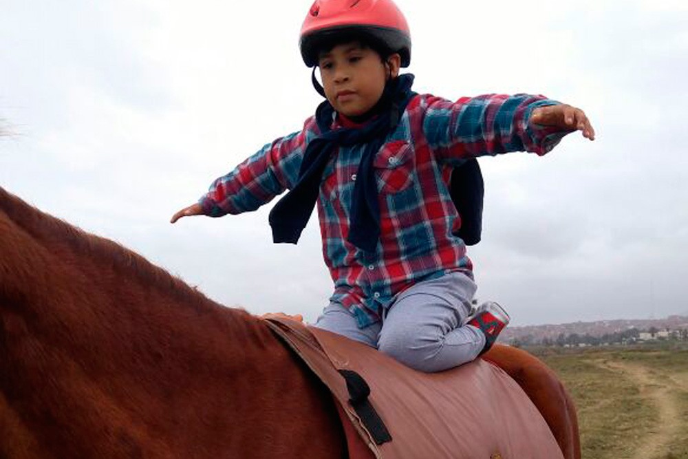 Sobre el caballo extendiendo los brazos