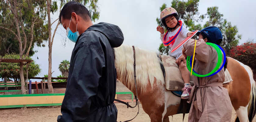 Niña trabajando con aros sobre el caballo