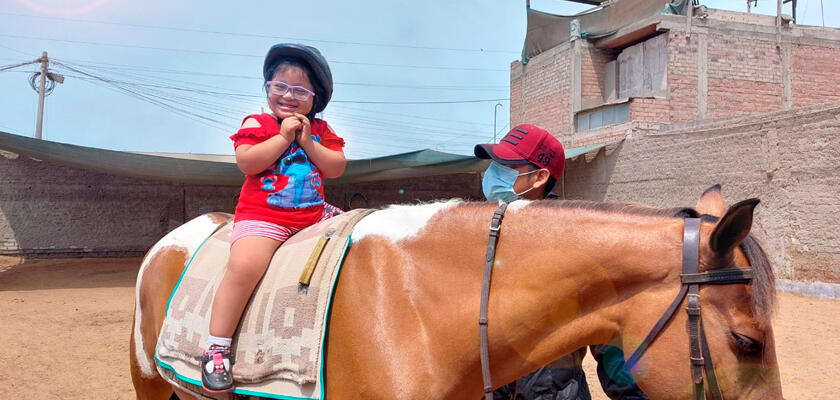 Niña emocionada sobre el caballo